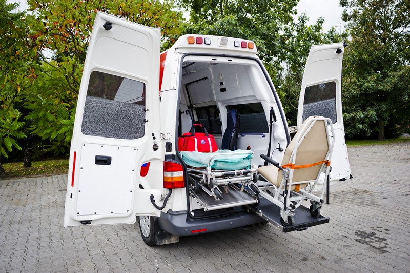 Ambulans z otwartymi drzwiami, noszami i krzesłem transportowym